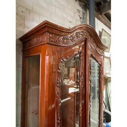 48 - An ornately carved display cabinet with two internal shelves and two drawers underneath, 197cm high ... 