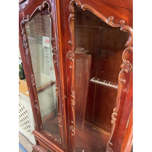 48 - An ornately carved display cabinet with two internal shelves and two drawers underneath, 197cm high ... 