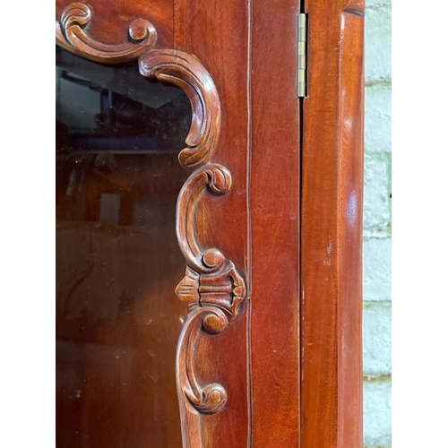 48 - An ornately carved display cabinet with two internal shelves and two drawers underneath, 197cm high ... 