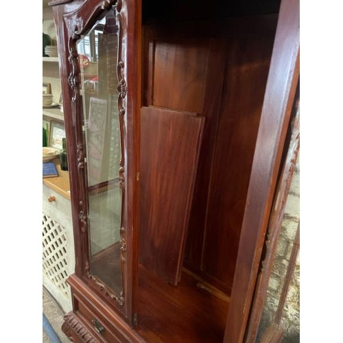 48 - An ornately carved display cabinet with two internal shelves and two drawers underneath, 197cm high ... 