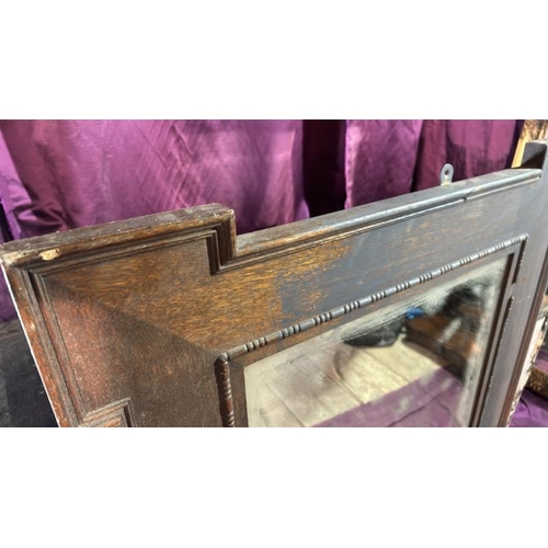 491 - A 20th century wall mirror with beviled edging, original glass and oak frame, requires some restorat... 