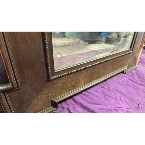 491 - A 20th century wall mirror with beviled edging, original glass and oak frame, requires some restorat... 