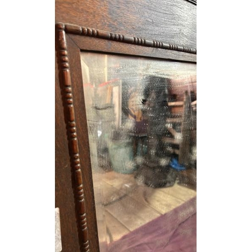 491 - A 20th century wall mirror with beviled edging, original glass and oak frame, requires some restorat... 