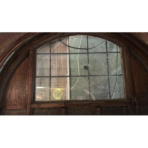 576 - A large 1920's gothic style front entry door with original cast iron features and glazed window, com... 