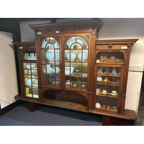 26 - An Edwardian oak top section of a dresser with ornately carved paneling and glazed features, on unas... 