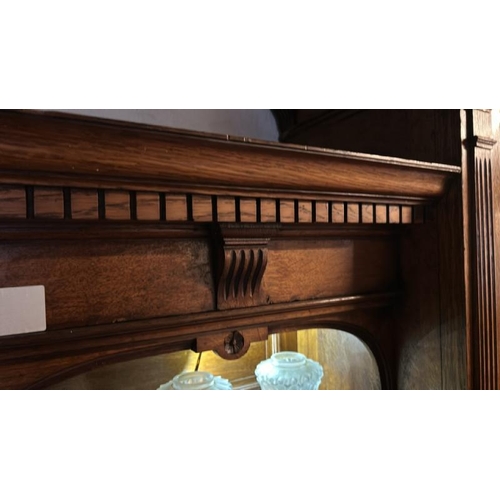 26 - An Edwardian oak top section of a dresser with ornately carved paneling and glazed features, on unas... 