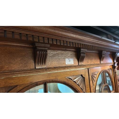 26 - An Edwardian oak top section of a dresser with ornately carved paneling and glazed features, on unas... 