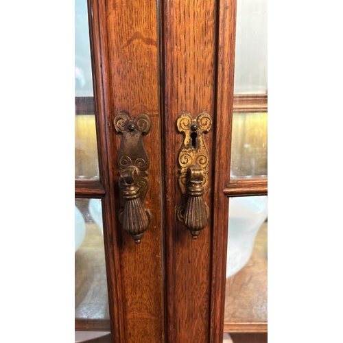 26 - An Edwardian oak top section of a dresser with ornately carved paneling and glazed features, on unas... 