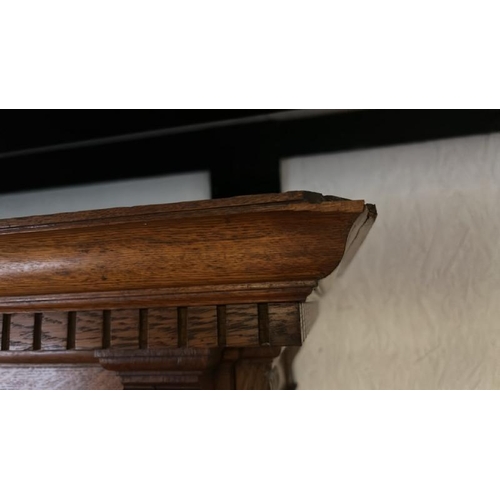 26 - An Edwardian oak top section of a dresser with ornately carved paneling and glazed features, on unas... 