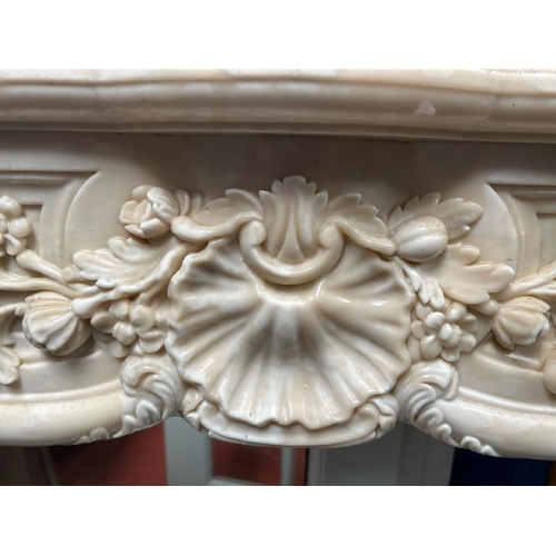 53 - A white marble resin copy fireplace surround, on authentic white marble base, profusely decorated wi... 