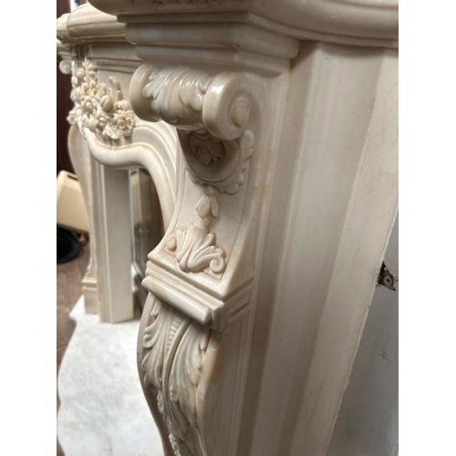 53 - A white marble resin copy fireplace surround, on authentic white marble base, profusely decorated wi... 