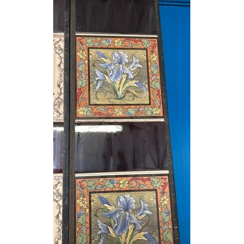 567 - Half set of three blue iris fireplace tiles, each 14cm squared, with metal tile holder  / All lots a... 