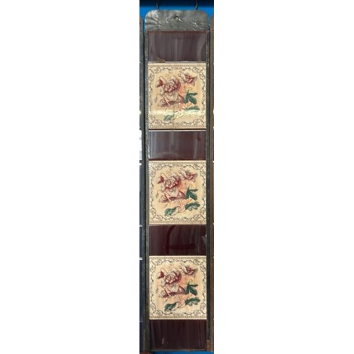 568 - Half set of three floral fireplace tiles, each 14.5x15cm, with metal tile holder   / All lots are lo... 