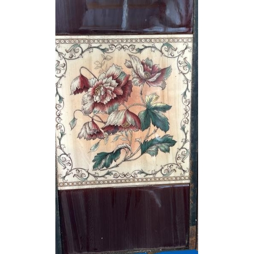 568 - Half set of three floral fireplace tiles, each 14.5x15cm, with metal tile holder   / All lots are lo... 