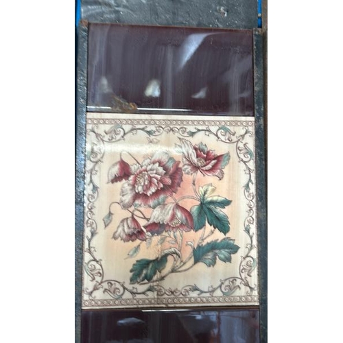 568 - Half set of three floral fireplace tiles, each 14.5x15cm, with metal tile holder   / All lots are lo... 