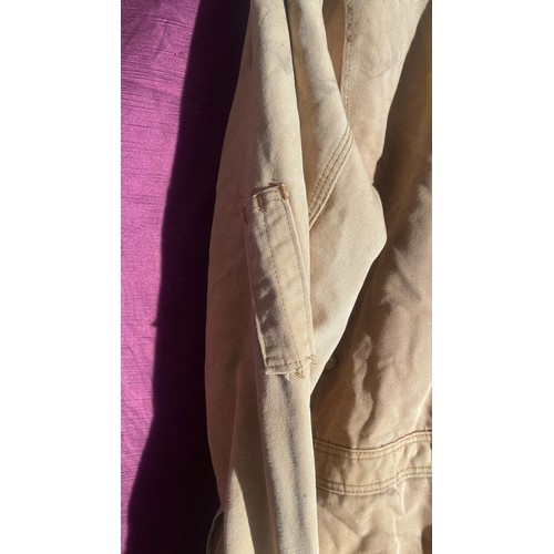 730 - Carhartt beige coverall features multiple pockets and snap closures.   / All lots are located at The... 