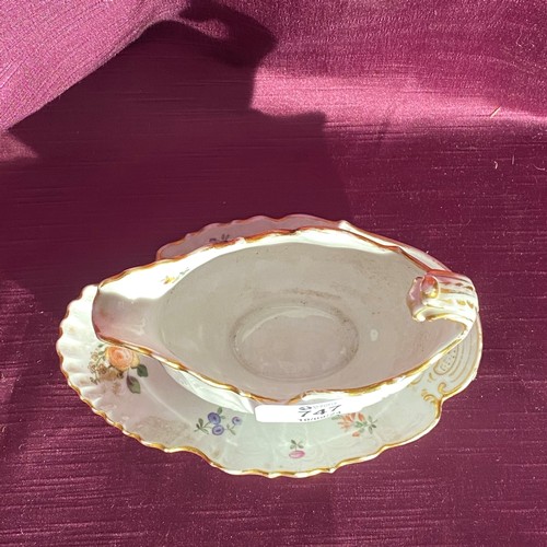 747 - A porcelain gravy boat with an attached underplate is showcased. It features gold accents and floral... 