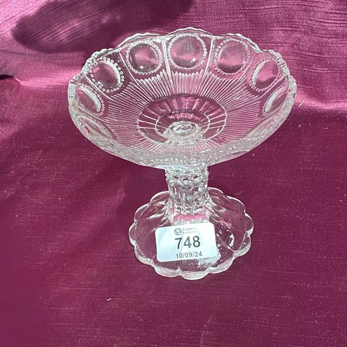 748 - Vintage glass compote with scalloped edge and intricate raised pattern. It is clear glass and stands... 