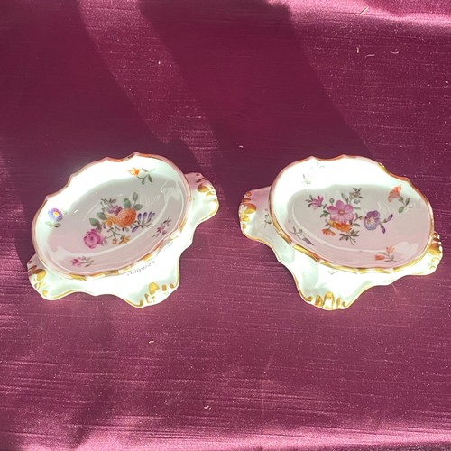 749 - Pair of porcelain salt cellars with floral motifs and gilt accents, featuring a scalloped edge desig... 