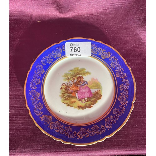 760 - A porcelain plate with cobalt blue and gold detailing, featuring a romantic couple scene. It is mark... 