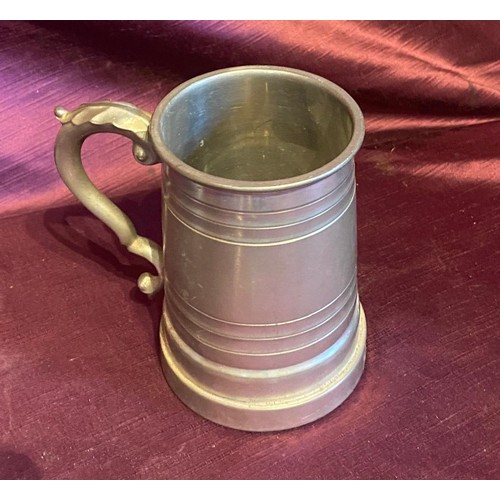 868 - One pewter tankard and five spoons. The pewter tankard showcases a classic design with scroll handle... 