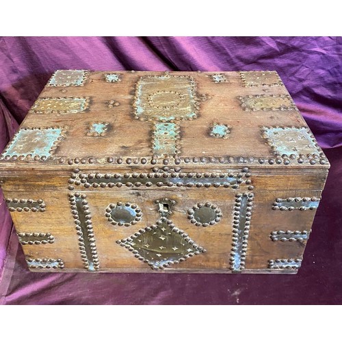 693 - A middle eastern teak campaign chest, with beaten brass bounds and studded structure / All lots are ... 