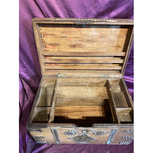 693 - A middle eastern teak campaign chest, with beaten brass bounds and studded structure / All lots are ... 