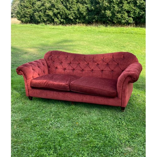 695 - A deep red buttoned Chesterfield sofa with scroll over arms and humped back, good classic style, in ... 