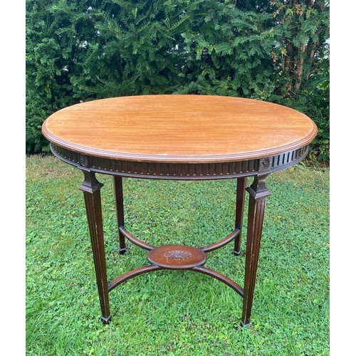 706 - A c.1900 Sheraton revival oval centre table with four fluted legs, central stretcher and fluted frie... 