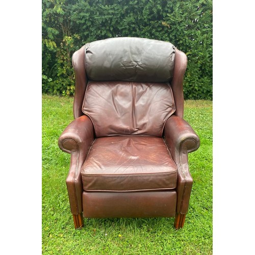 712 - A 20th century Georgian style wingback tanned leather reclining chair, in very good condition and of... 