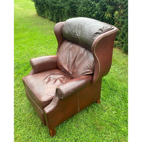 712 - A 20th century Georgian style wingback tanned leather reclining chair, in very good condition and of... 