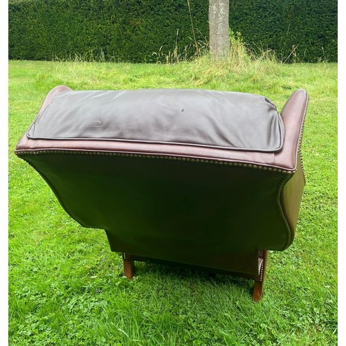 712 - A 20th century Georgian style wingback tanned leather reclining chair, in very good condition and of... 