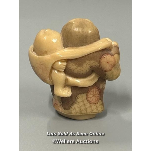 20 - Two carved tagua nut netsukes one in the form of a mother and child, 4.5cm high, the other in the fo... 