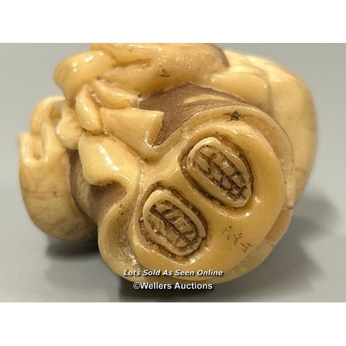 20 - Two carved tagua nut netsukes one in the form of a mother and child, 4.5cm high, the other in the fo... 