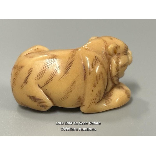 20 - Two carved tagua nut netsukes one in the form of a mother and child, 4.5cm high, the other in the fo... 