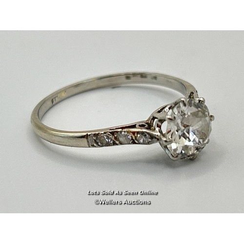 305 - A solitaire diamond ring with an old European cut diamond claw set between diamond set shoulders. Es... 