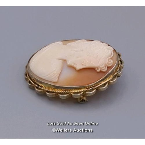 308 - Two modern oval shell cameo brooches, the first mounted in 9ct gold with twisted wire border and rol... 