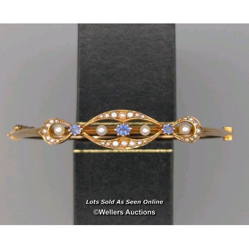 309 - Antique bangle of hinged design, the top supporting three oval sapphires and four pearls within a bo... 