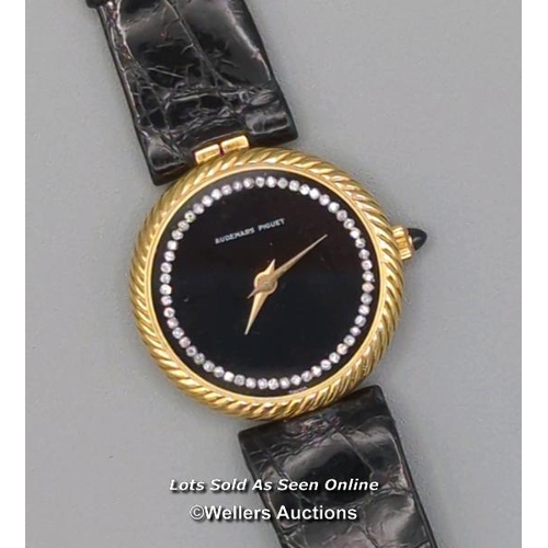 310 - Audemars Piguet. A ladies gold 1970's wristwatch, the black signed dial set with 56 round brilliant ... 