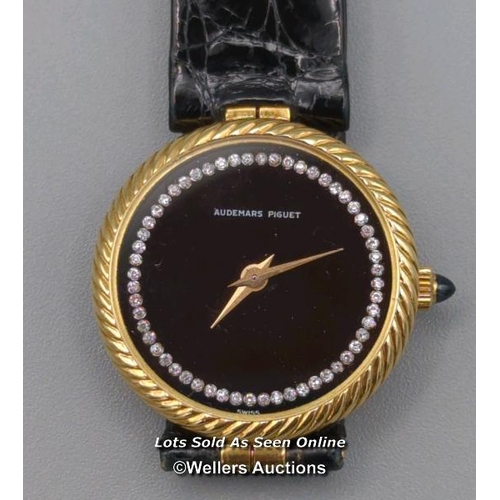 310 - Audemars Piguet. A ladies gold 1970's wristwatch, the black signed dial set with 56 round brilliant ... 