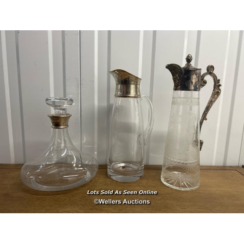 32 - Three glass decanters, two of which have sterling silver tops, smallest reading ‘hsbc world match pl... 