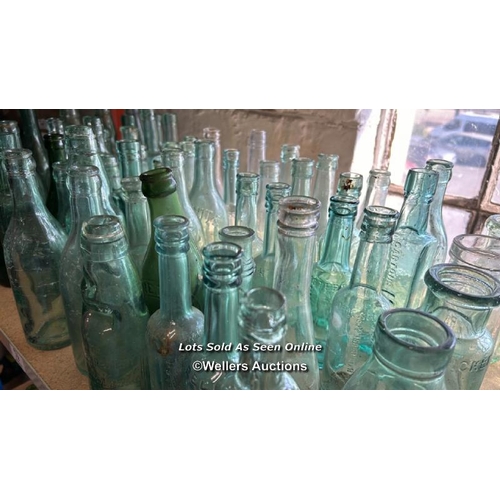 73 - A very large collection of assorted vintage glass bottles and jars including R Whites, Bovril, Carlt... 