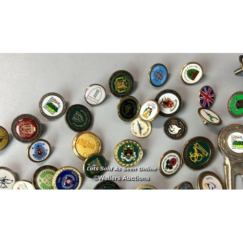 152 - A large collection of Golf tee markers including The Open - St Andrews 2005 / AN24