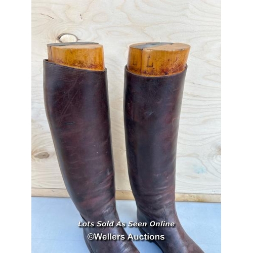 14 - A pair of brown leather riding boots, with wooden shoe trees from Thomas, 5 Saint James Street, Lond... 