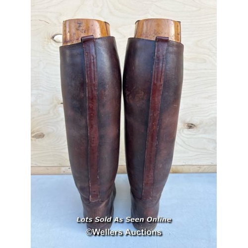 14 - A pair of brown leather riding boots, with wooden shoe trees from Thomas, 5 Saint James Street, Lond... 