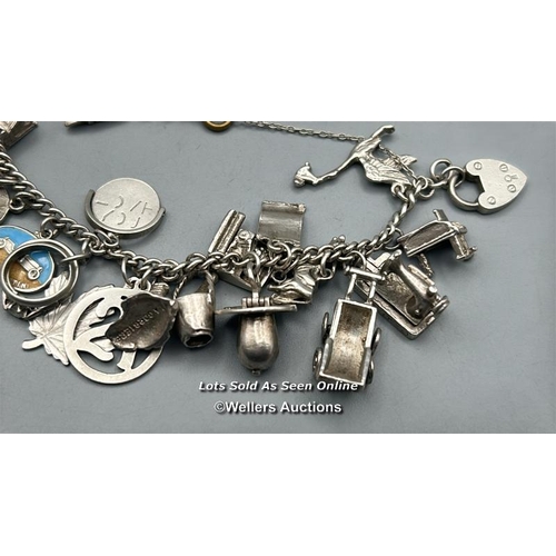 70 - Approx. 30 assorted charms most stamped 'Silver' on a white metal bracelet chain, total weight 58.9g... 