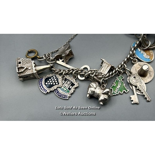 70 - Approx. 30 assorted charms most stamped 'Silver' on a white metal bracelet chain, total weight 58.9g... 