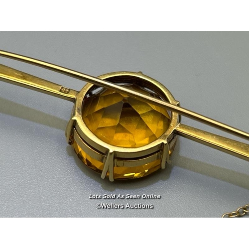 77 - Citrine bar brooch. Round citrine diameter 18.9mm, estimated weight 11.64ct, claw set on a tapering ... 