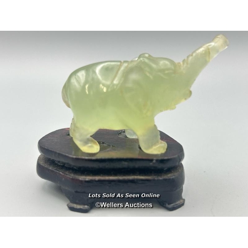 40 - A small carved jade figure of an Elephant on wooden base, 3cm high, 23.5g in fitted box (Lot subject... 