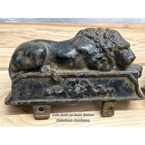 312 - A pair of cast iron lion finials / 22cm l x 15cm h